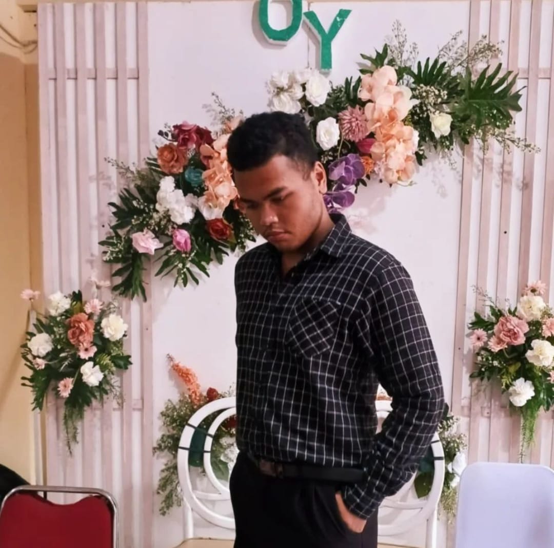 Potret Gielang Omar dengan latar gelap, mengenakan kemeja kasual berwarna gelap, tersenyum ramah